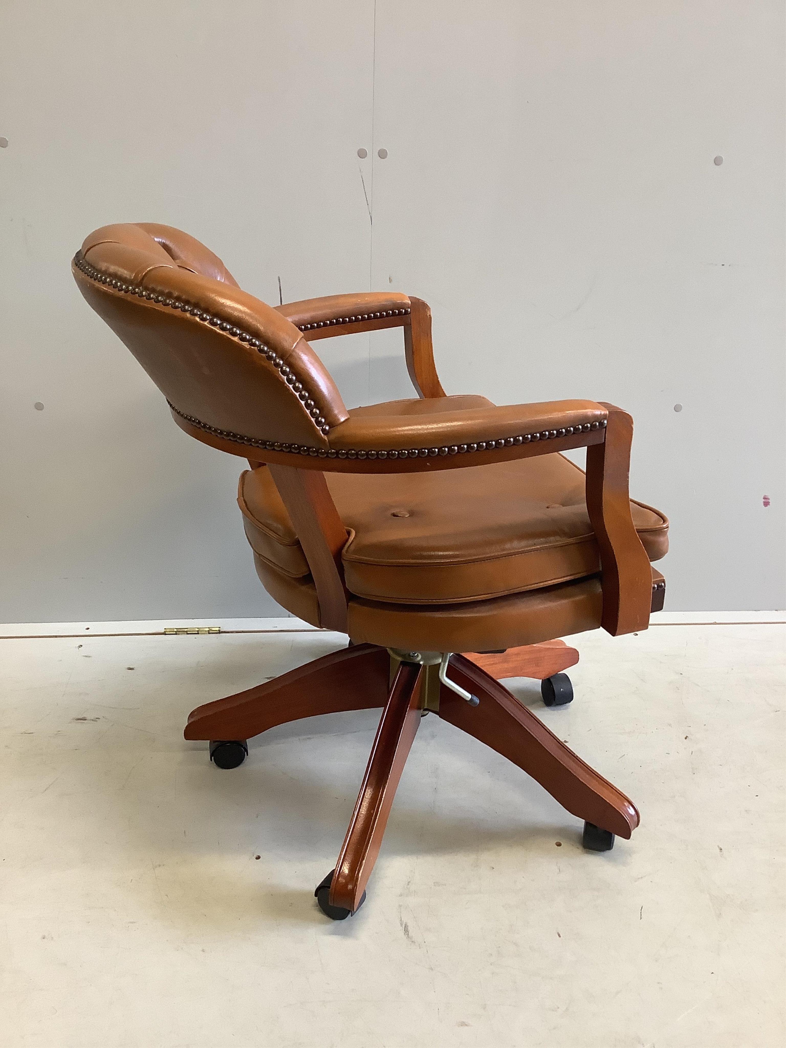 A modern mahogany and tan leather swivel desk chair, width 60cm, depth 50cm, height 86cm. Condition - good